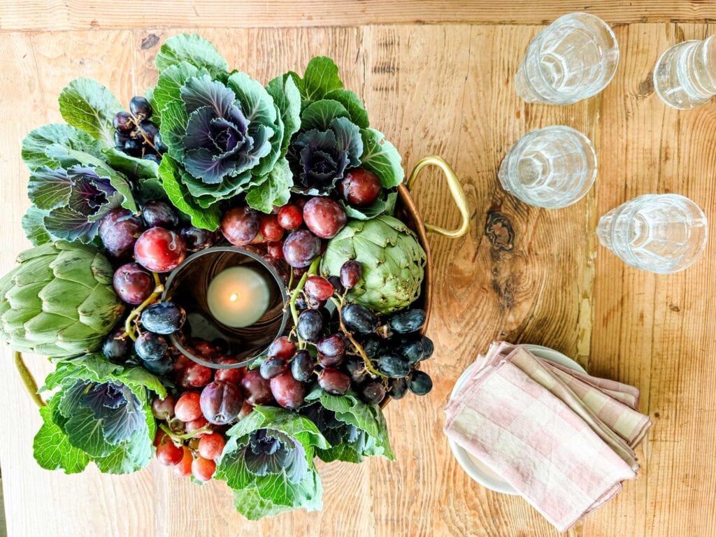 How to Make a Simple Autumn Centerpiece for Your Table - Ornamental cabbage, grapes, candles, pink checked napkins on plates.