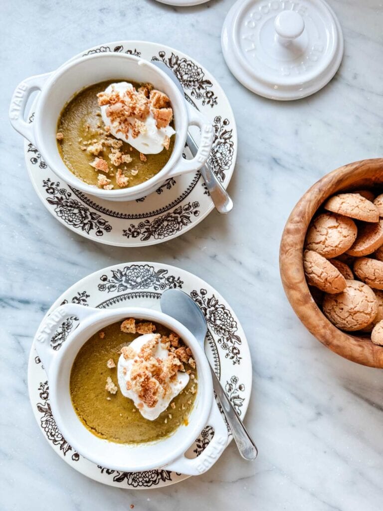 Pumpkin Spice Pot de Creme with Whipped Cream on Top - small Staub pots on brown floral plates with small cookies in wood bowls as topping. 