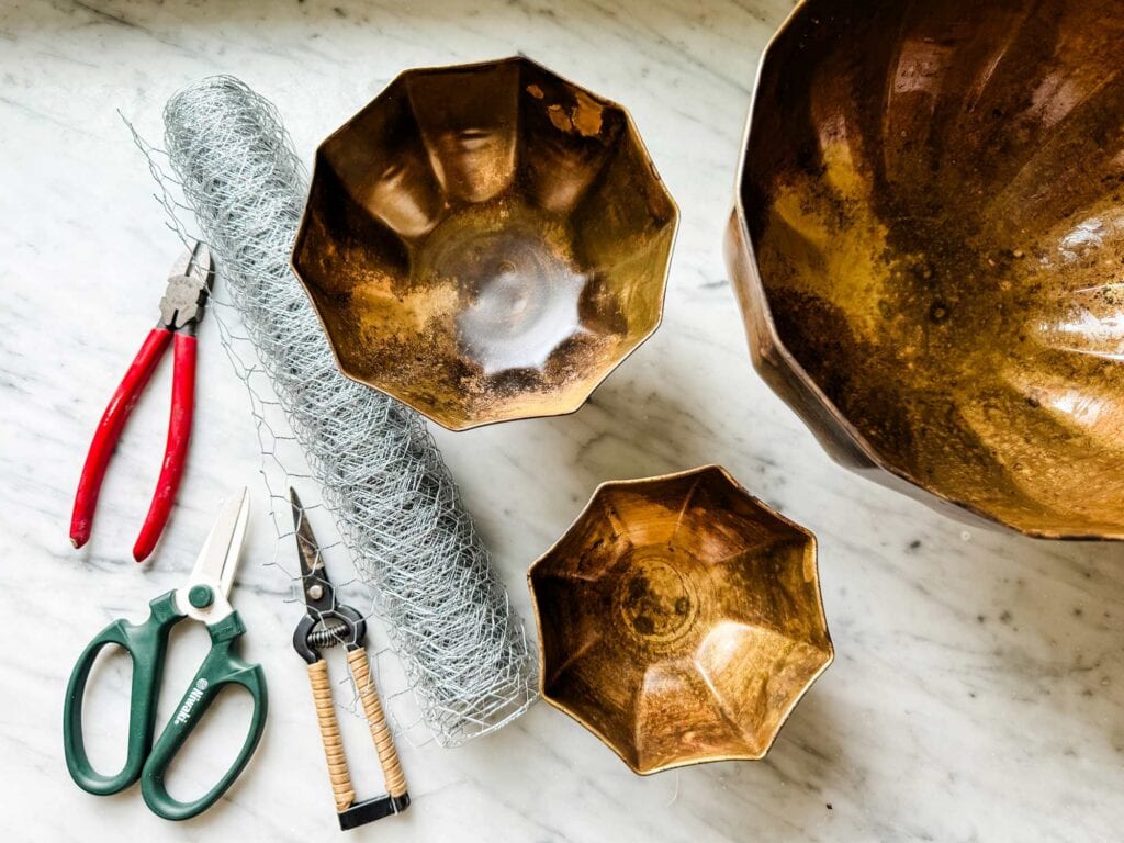 Gold vases in three sizes, wire cutter, scissors, pruners, chicken wire. 