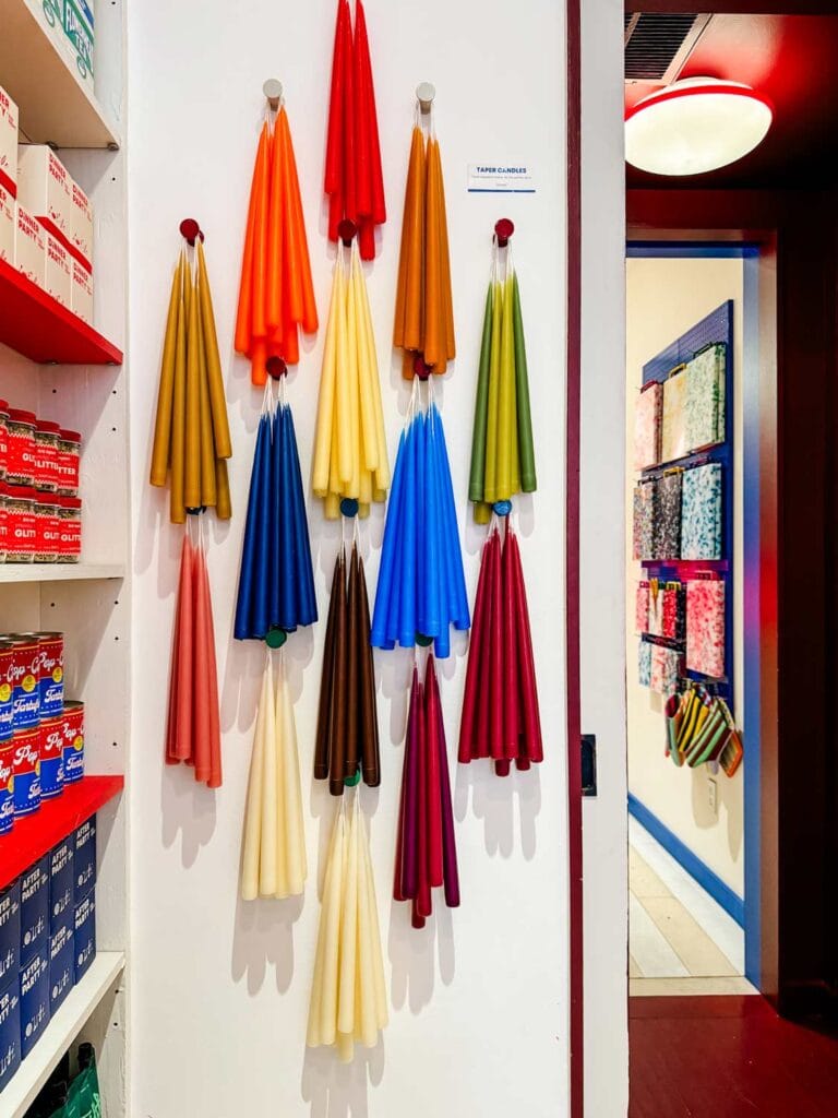 An assortment of colorful candles hang on the walls of Big Night. Next to the candles, shelves are stocked with gourmet food.