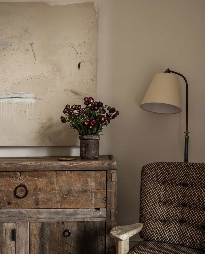 A chair and a hutch in different shades of brown decorate this room.