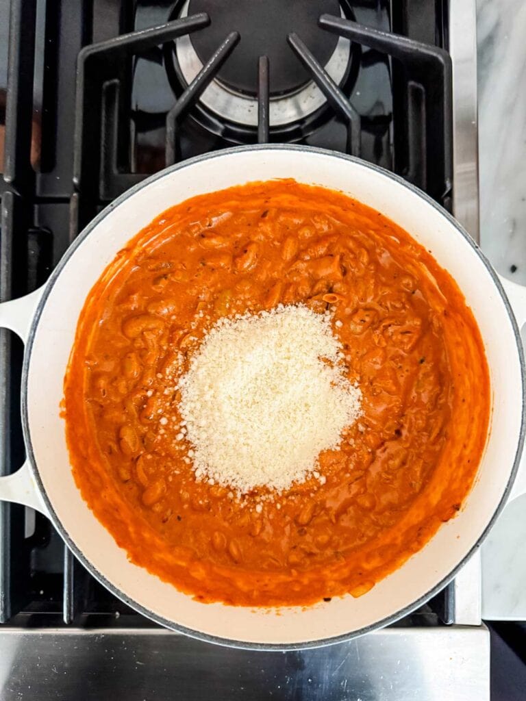 The last step in making the spicy tomato beans is adding pecorino cheese and mixing it in.