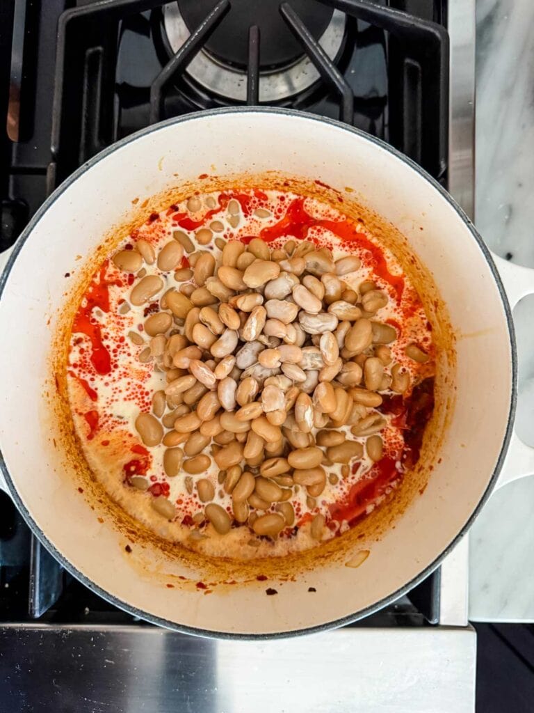 Cream, water, and cannellini beans have been added to caramelized onion and tomato paste mixture.