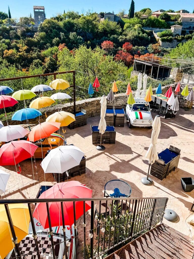 Colorful umbrellas shad the table at an outdoor cafe in Gordes, France.