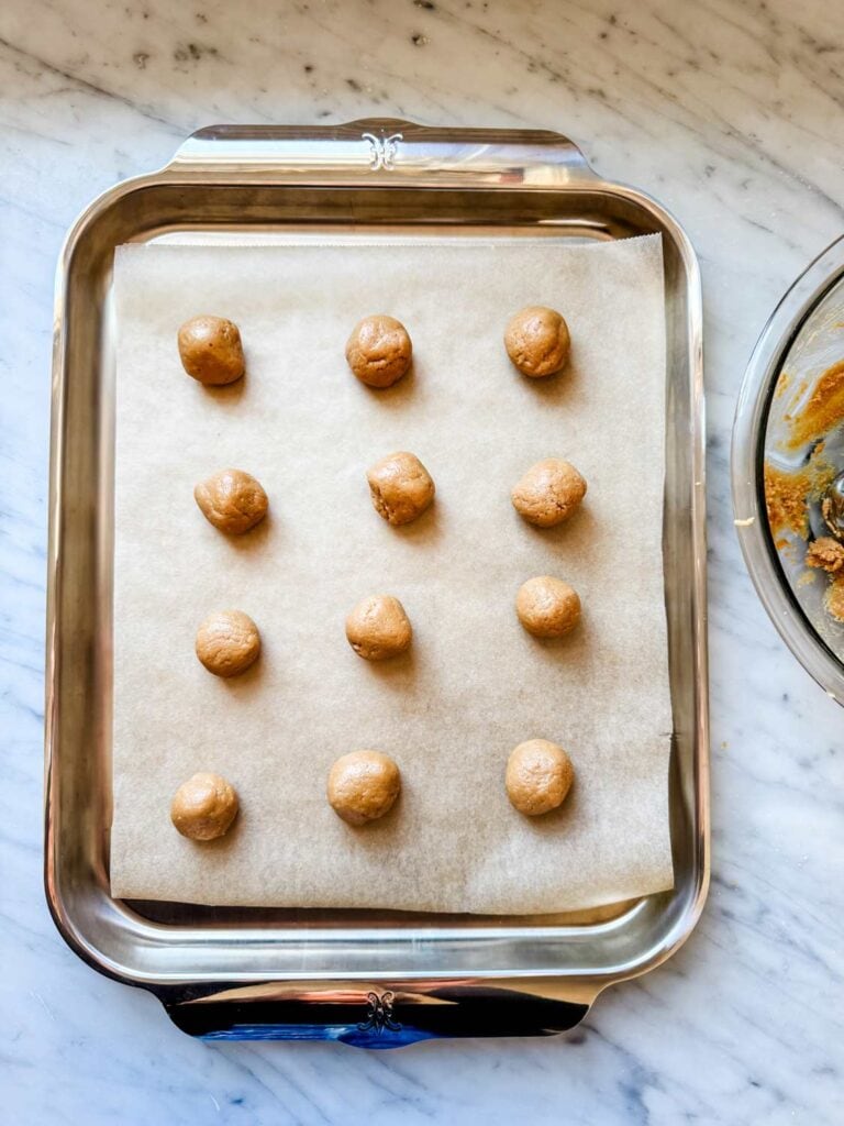 Peanut butter cookie balls on baking sheet.