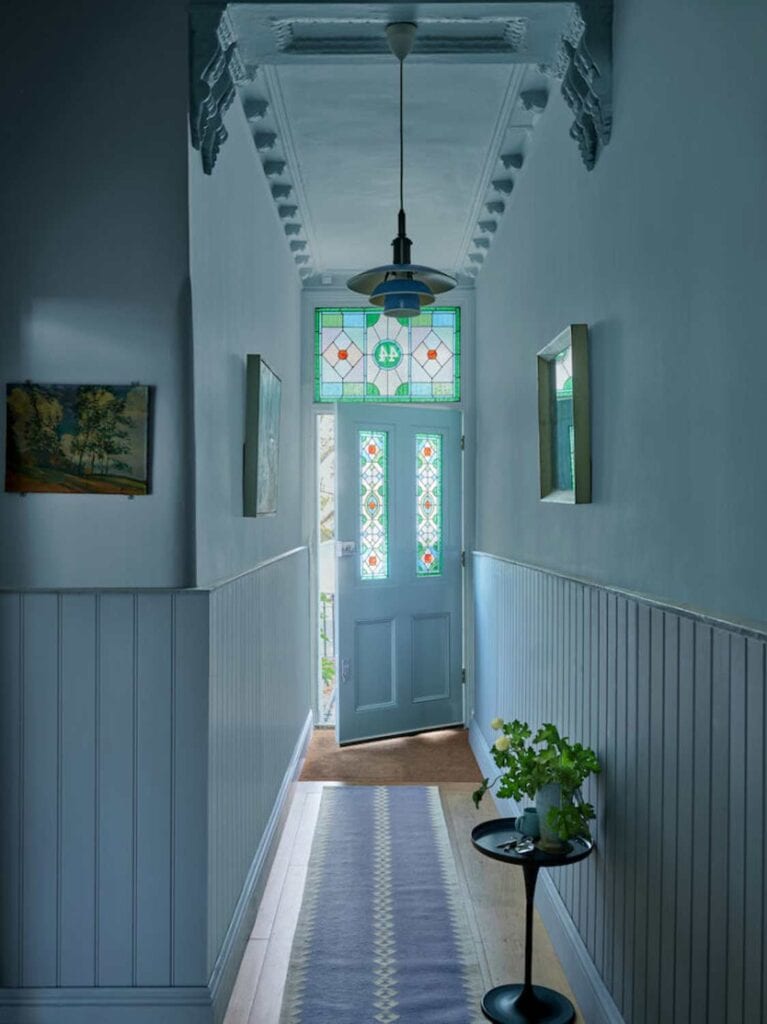 Entryway painted all light blue with stained glass door and side lights.