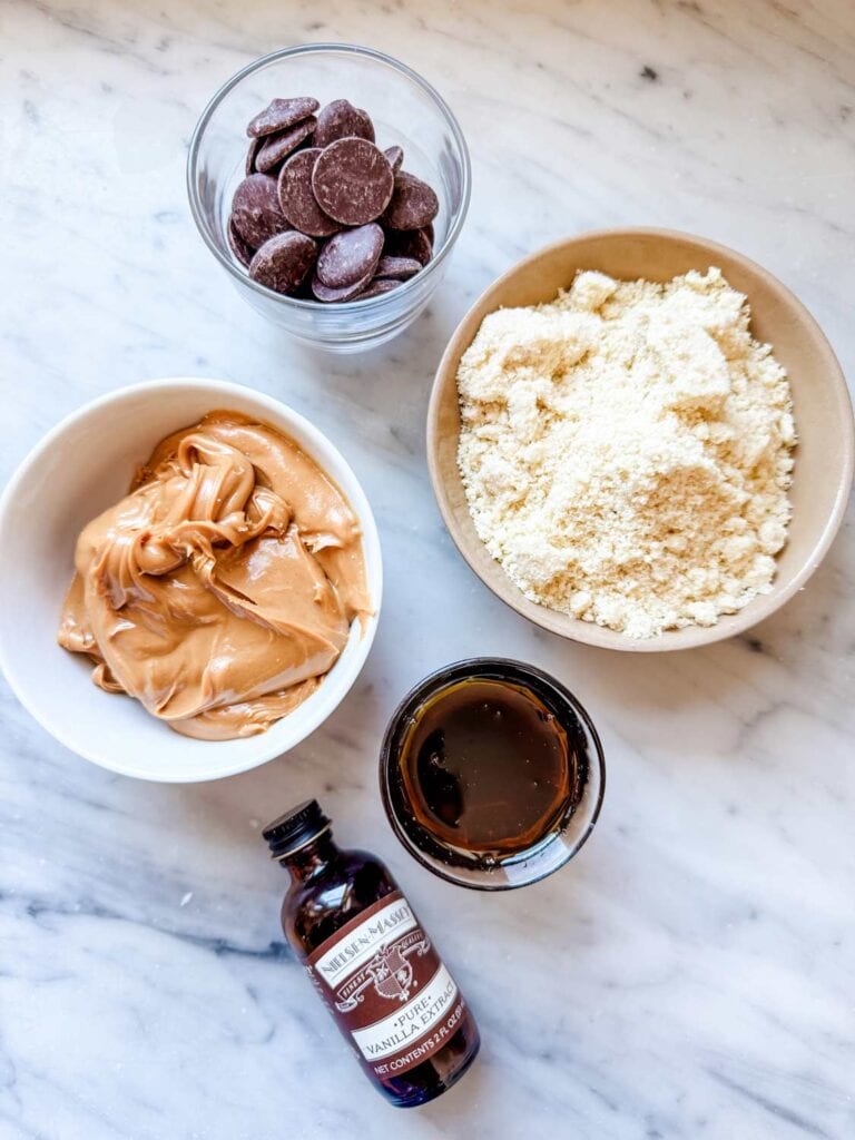 Small bowls, cups of ingredients for peanut butter cookies.