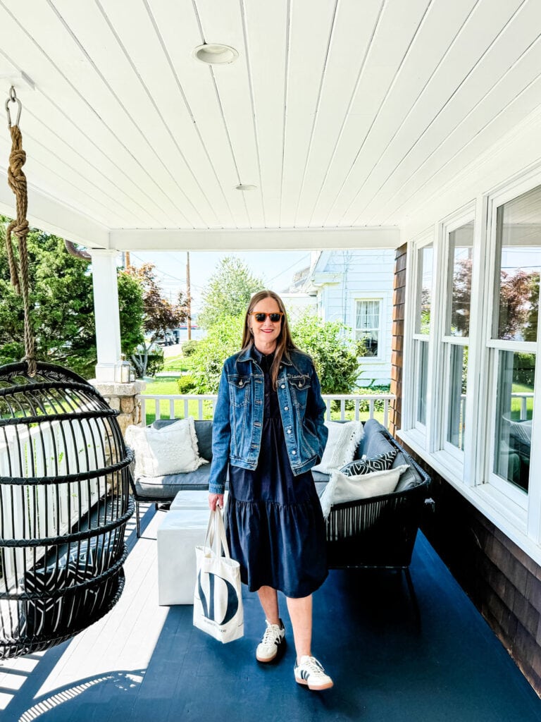 A women wearing a jean jacket with a button down shirts and a skirt.