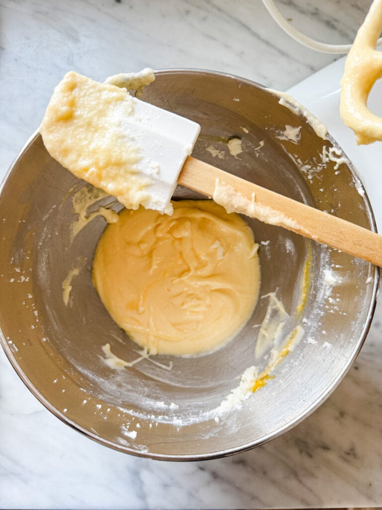 Cremed butter and sugar in a large mixing bowl with a spatula resting on top of the bowl.