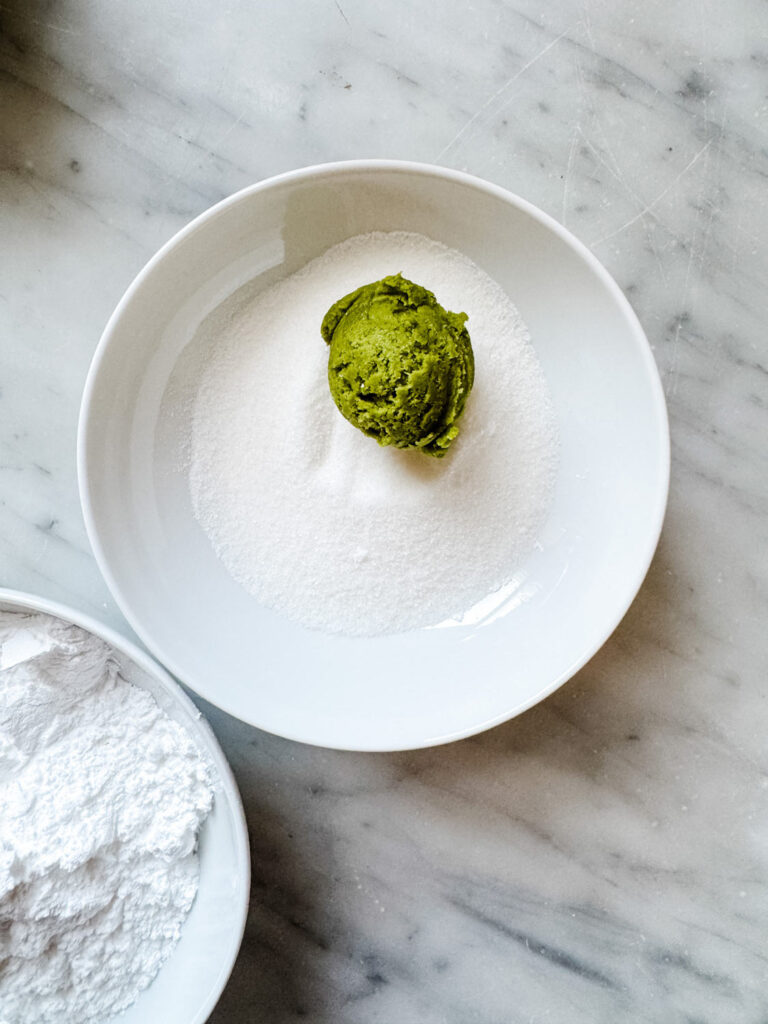 Matcha cookie dough balls are first rolled in granulated sugar.