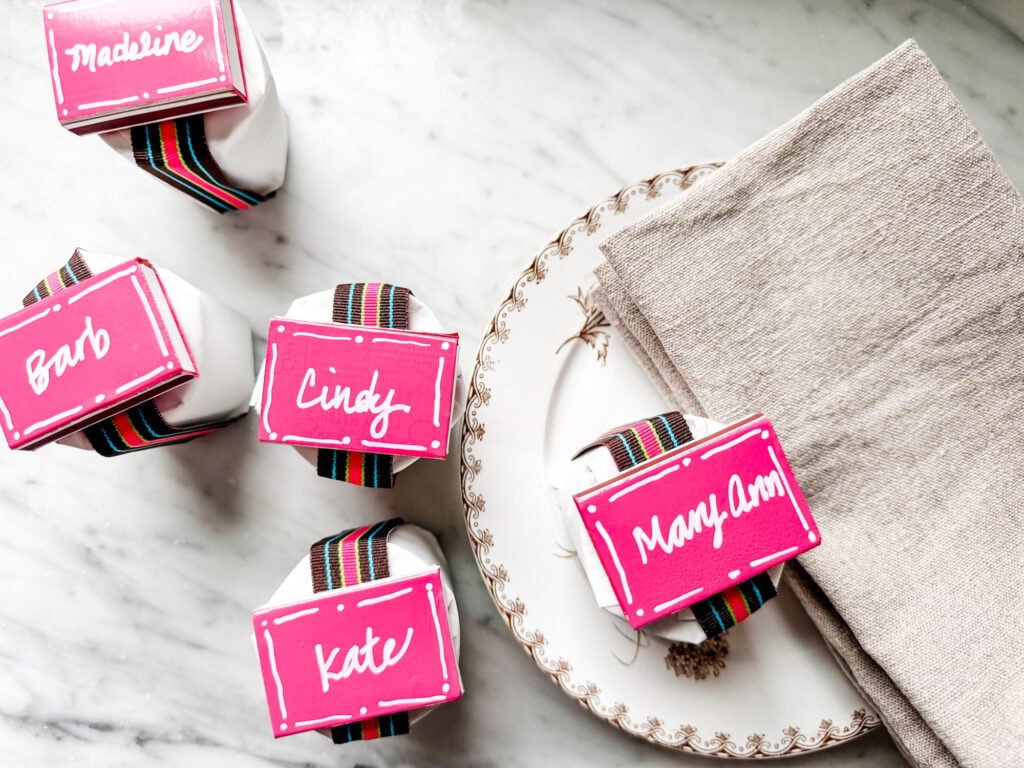 Pink personlaized matchbooks on top of packages with brown and pink striped ribbon. 