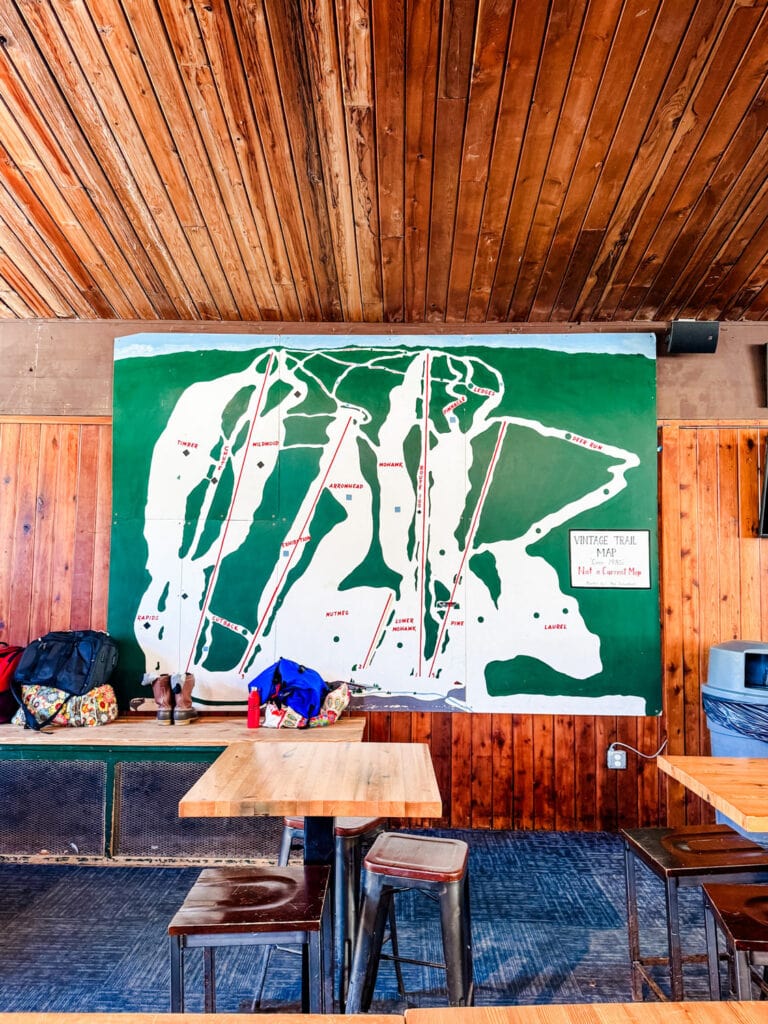 An old-fashioned trail map hangs on the wall inside the lodge.