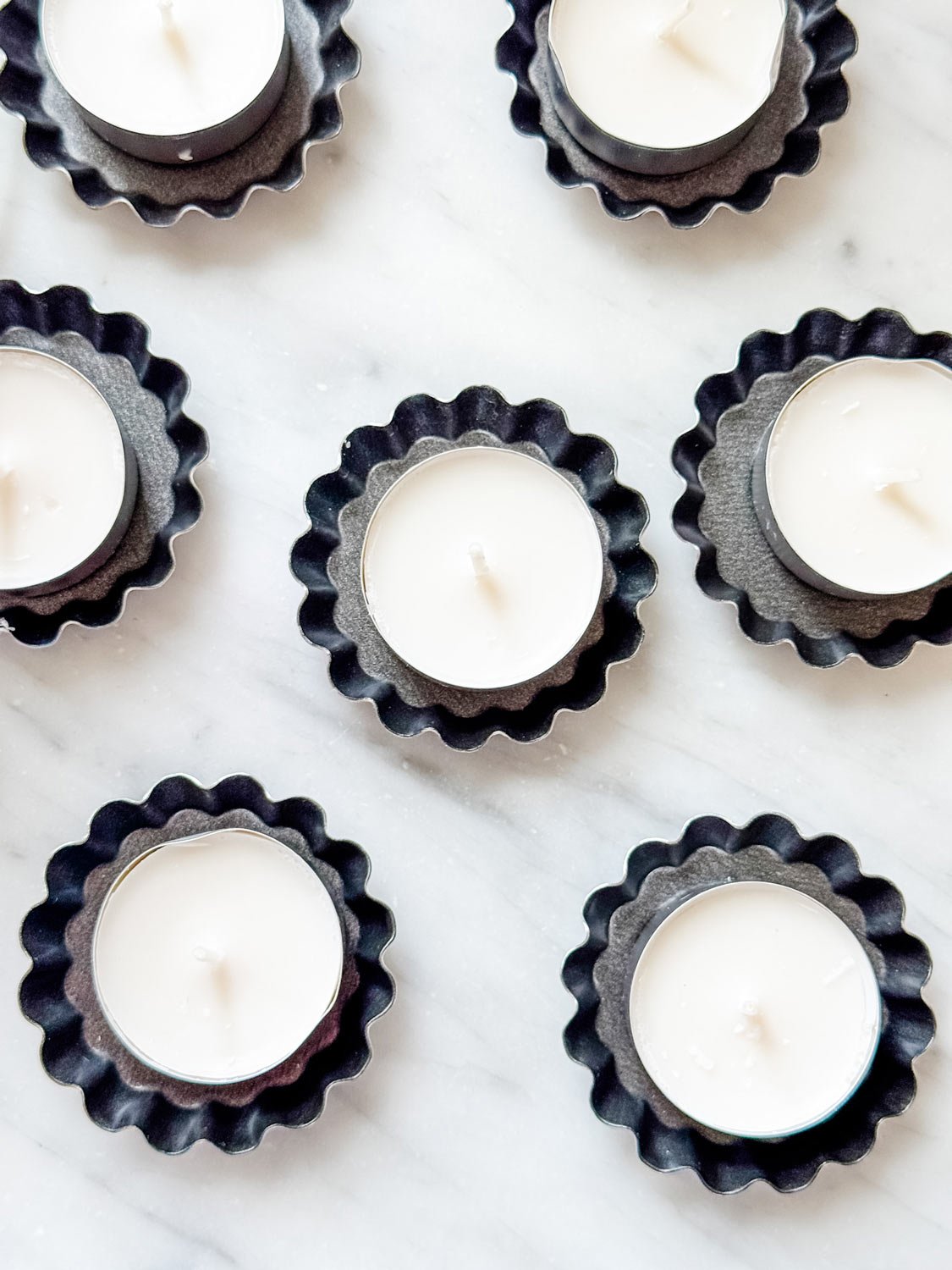 Tea lights in mini tart tins for setting a table for a French dinner party.