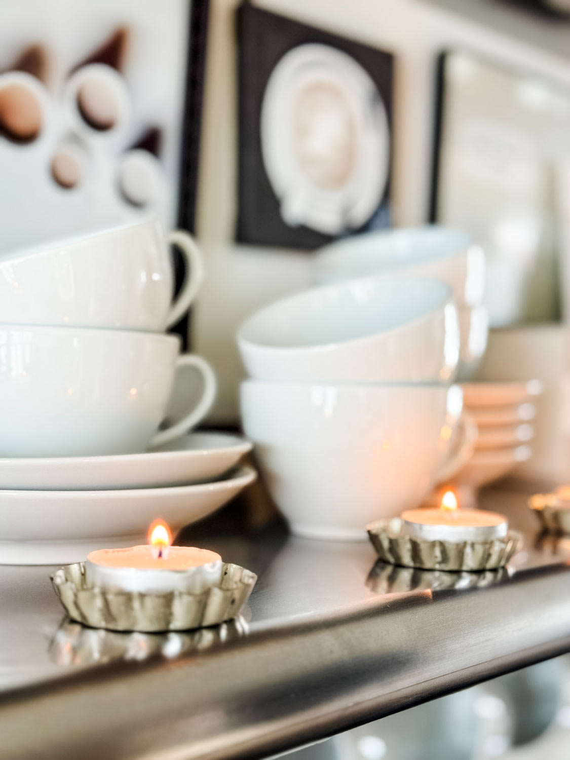 White Apilco cups and saucers on shelf with tea lights.