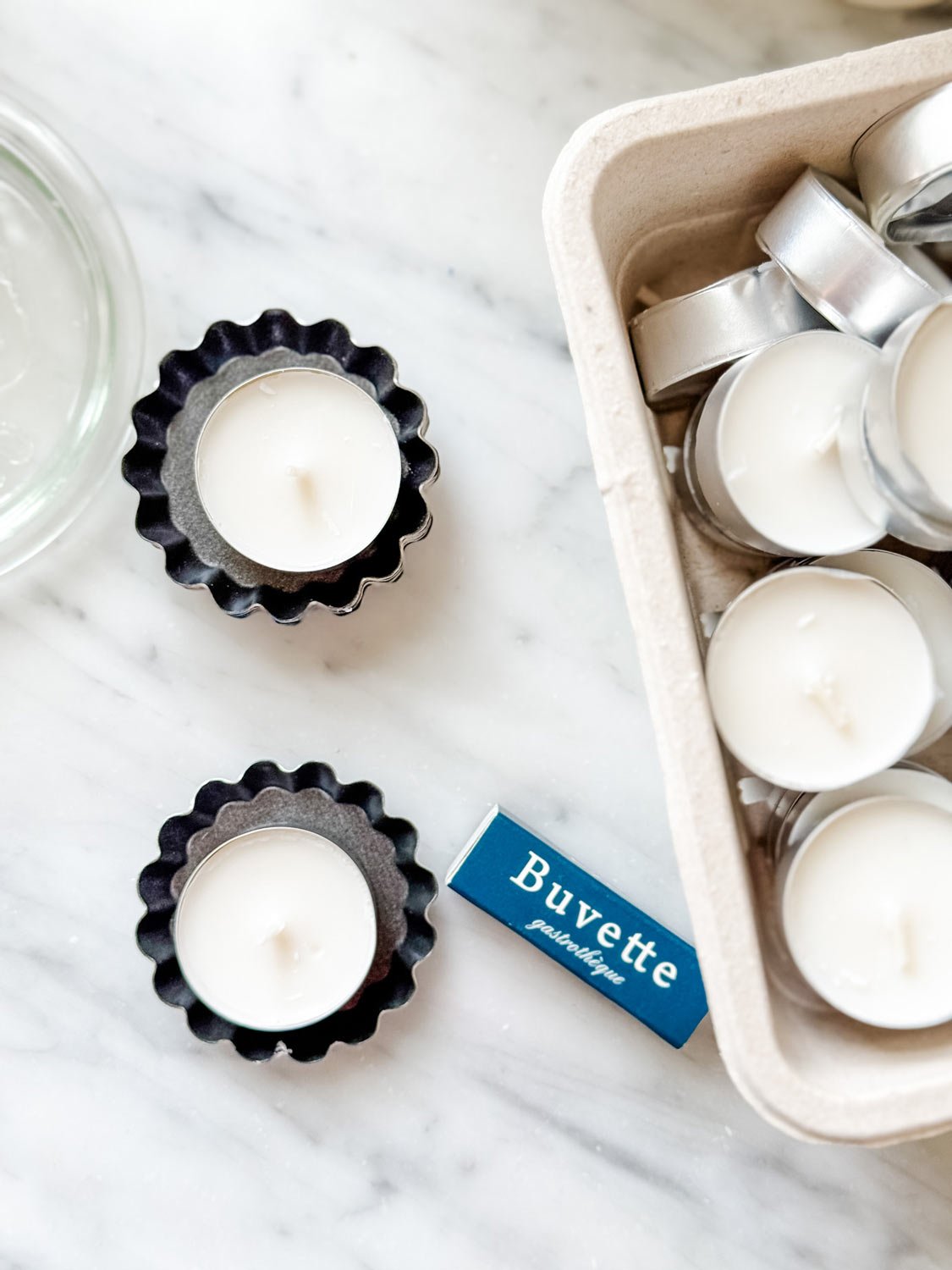 Tea lights in mini tart tins for setting a table for a French dinner party.