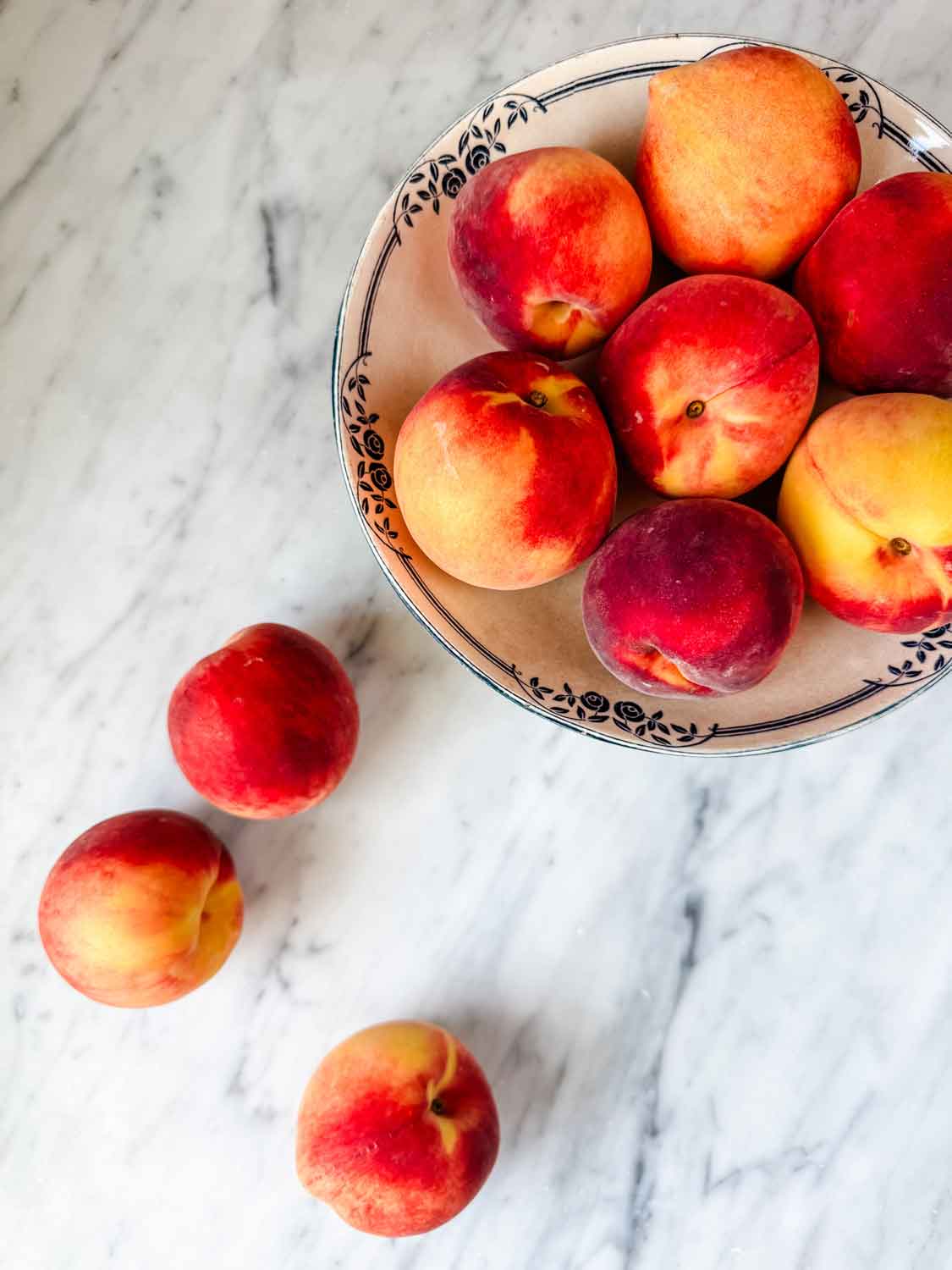 Peaches on countert and in vntage bowl.