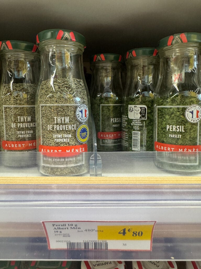 A variety of herbs on the shelf of a local grocery store in France.