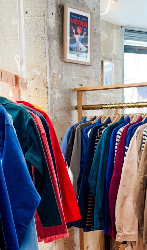 Authentic French workwear hangs on racks inside the store.