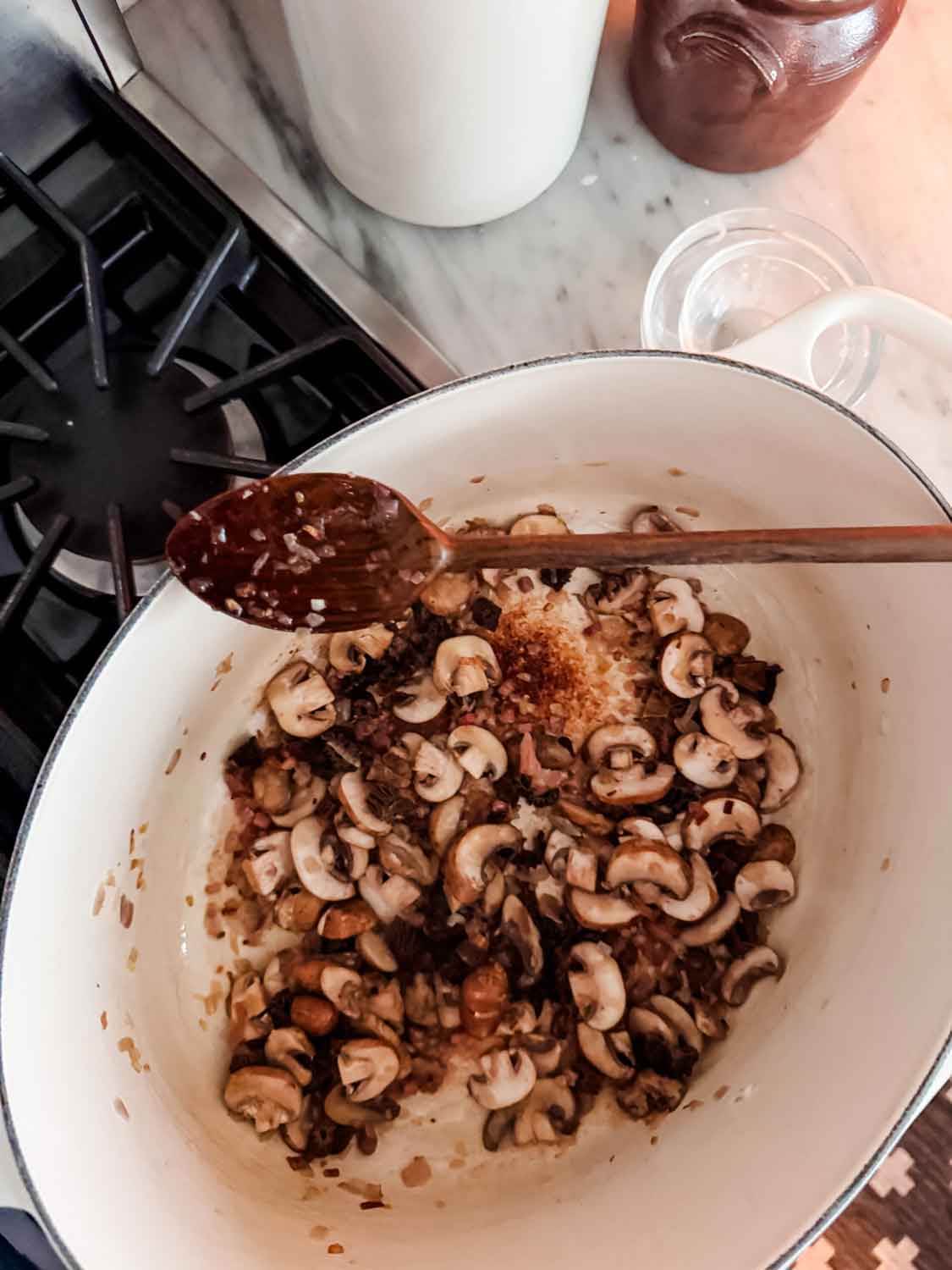 Both mushrooms are sautéing in a large Dutch oven.