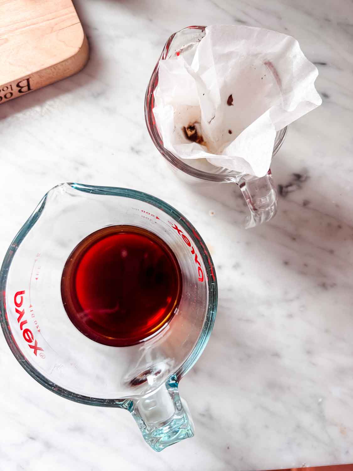 Morel mushrooms have been removed from the liquid, and the liquid has been poured through a coffee filter.