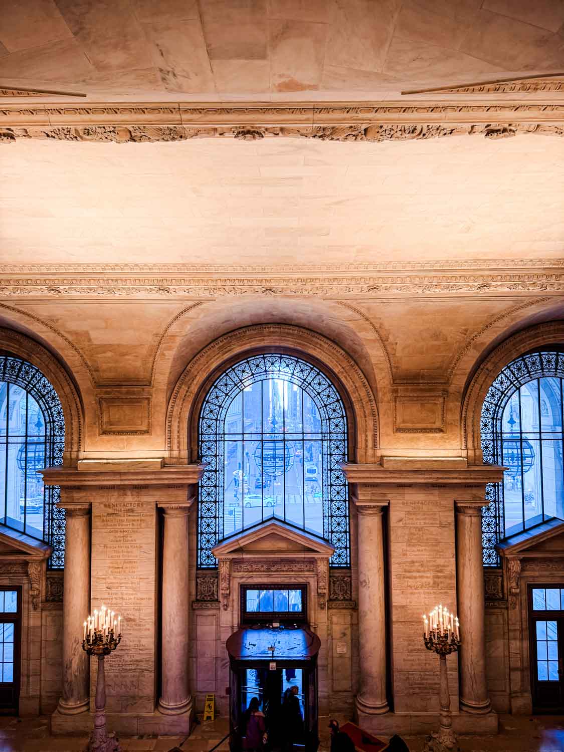 You can see the entrance to the New York Public Library from the second floor. Large rounded window run along the entire front wall of the library.