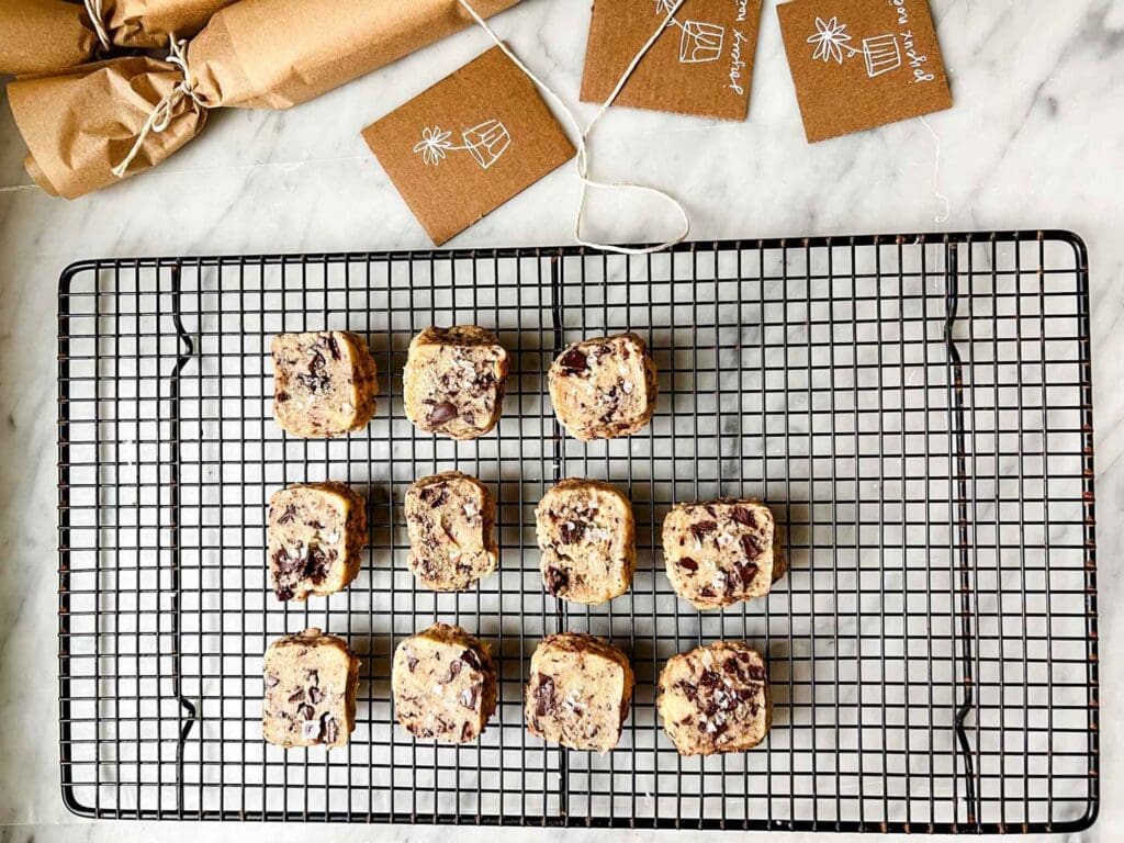 Chocolate chunk shortbread cookies topped with sea salt are cooling on a wire rack.