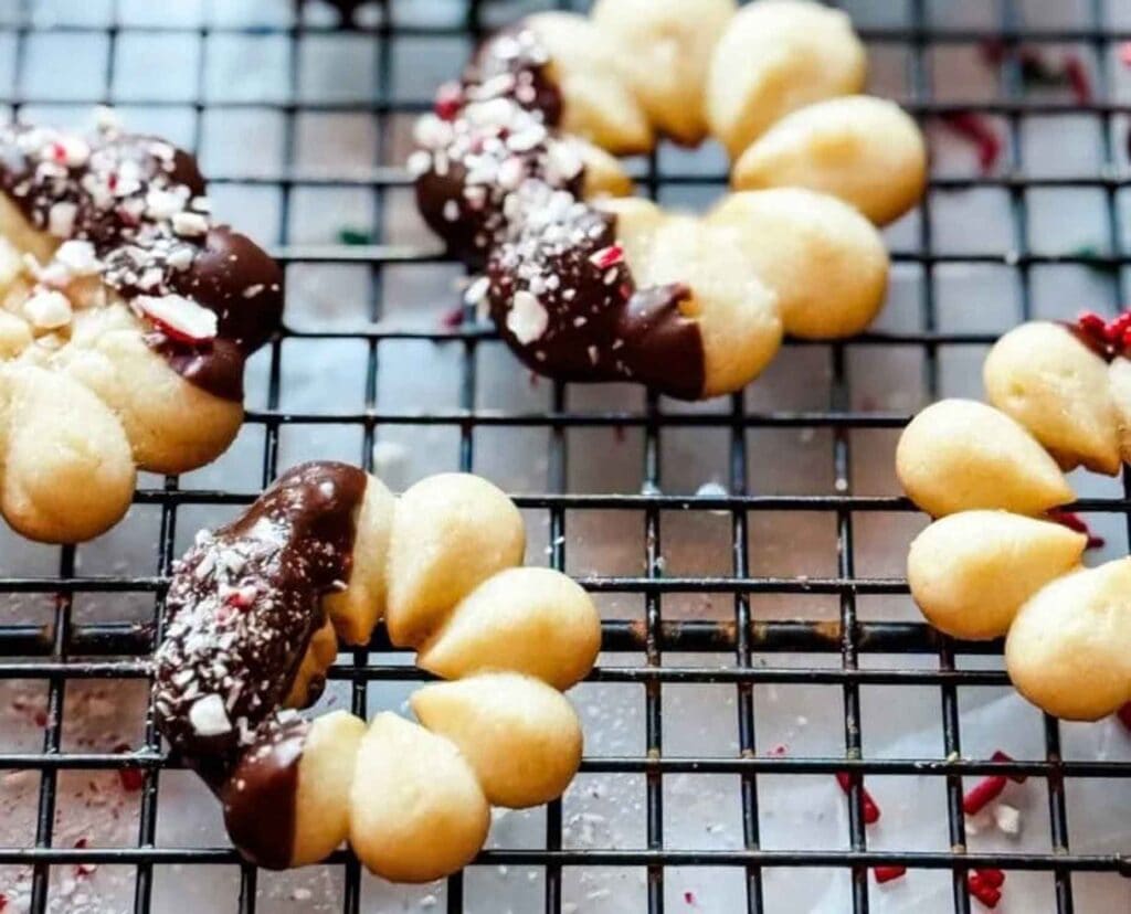 Spritz butter cookies are dipped in chocolate and and can be decorated depending on the holiday you are celebrating.