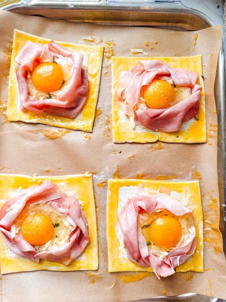 An egg is placed into the created well and is topped with salt and pepper.