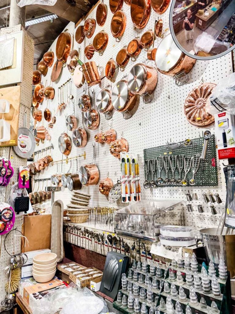 Cookie scoops, pastry bag tips, and all kinds of copper pots and copper molds line the pegboard wall in this section of E. Dehillerin kitchen supply store in Paris.