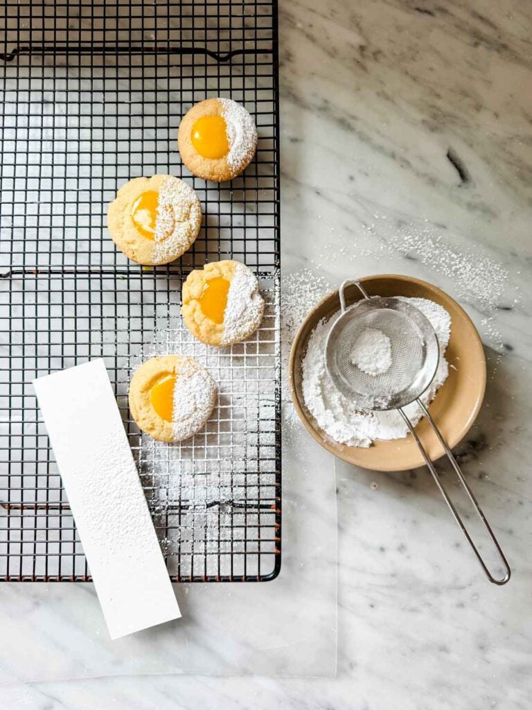 A strip of cardboard or cardstock has been used to hold over half the cookie, while powdered sugar was used to dust the other half.