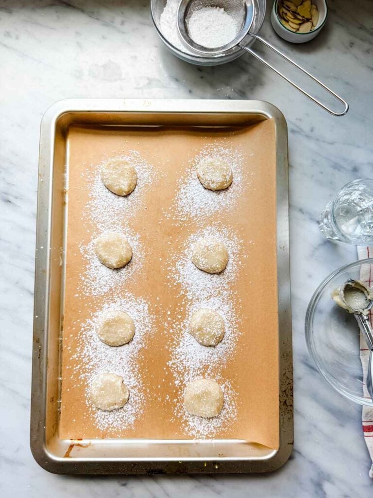 The smooth cookies are dusted generously with powdered sugar.