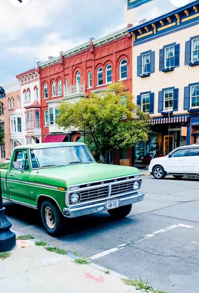 Main street in Hudson, New Yorkl with old green Frod pickup truck.