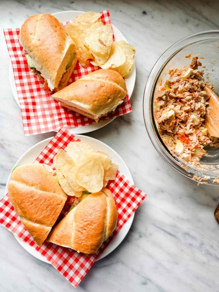 California tuna sandwiches are served on small white plates.