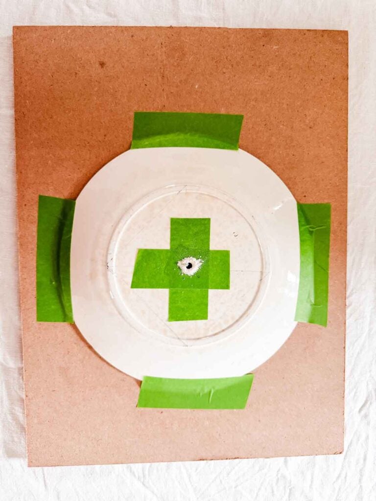 Tape in a plus formation with drilled hole in the center of the tape on the plate.
