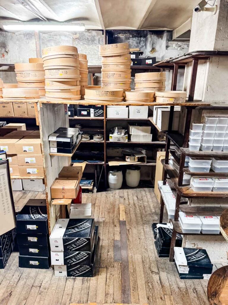 Staub boxes are stacked on the wood floors, and other kitchen supplies line the shelves in this corner of E. Dehillerin in Paris.