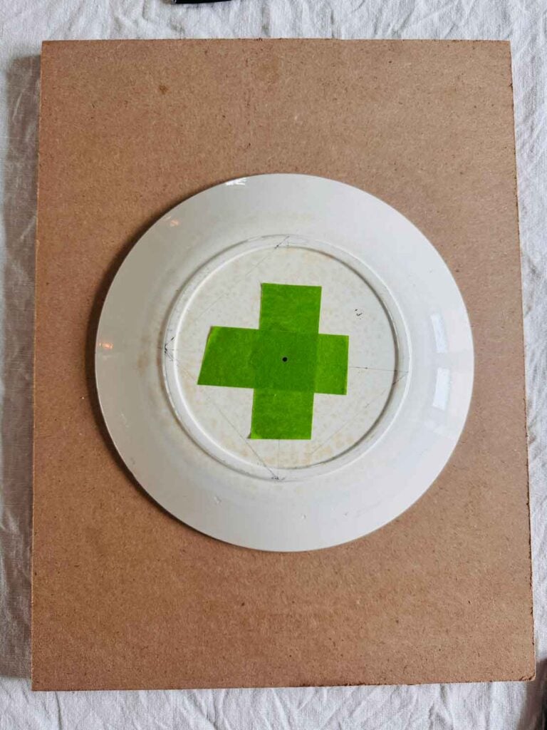 Tape in a plus formation with dot in the center of the tape on the plate.