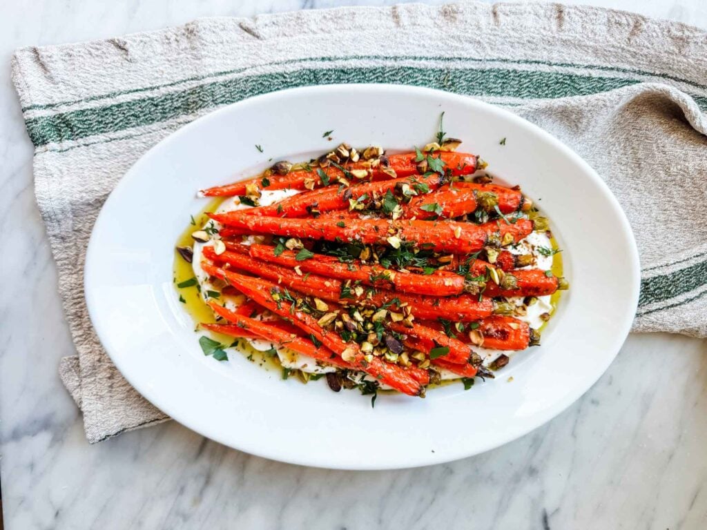 Roasted carrots on white platter.