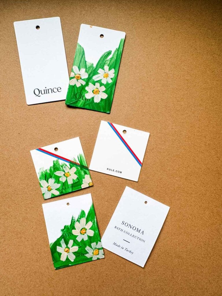 Clothing tags as is and some painted with green and little daisies.