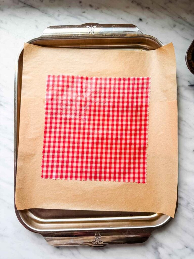 The beeswax pellets have been melted in the oven on this piece of fabric. It was then smoothed with a paintbrush to get a smooth, even layer on the fabric.