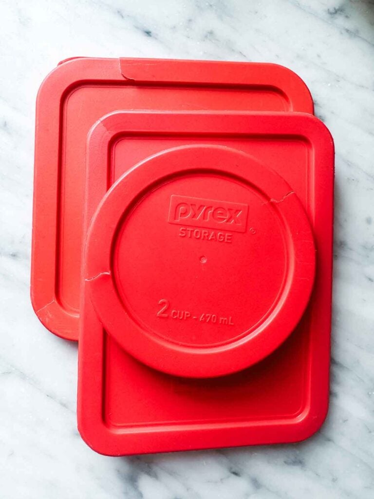 Food container lids, sitting on a kitchen counter, are all cracked around the edges.