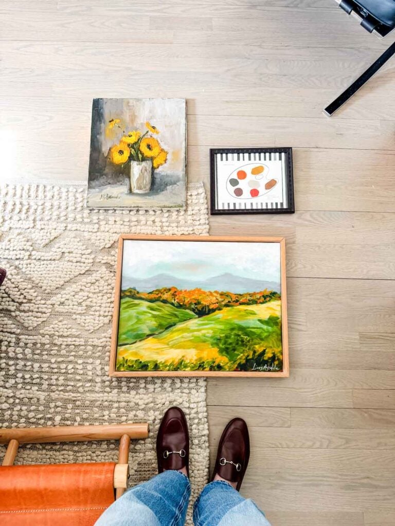 Art on floor with rug, loafers.