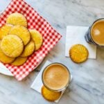Sablés Breton cookies are plated and served with two cups of espresso.