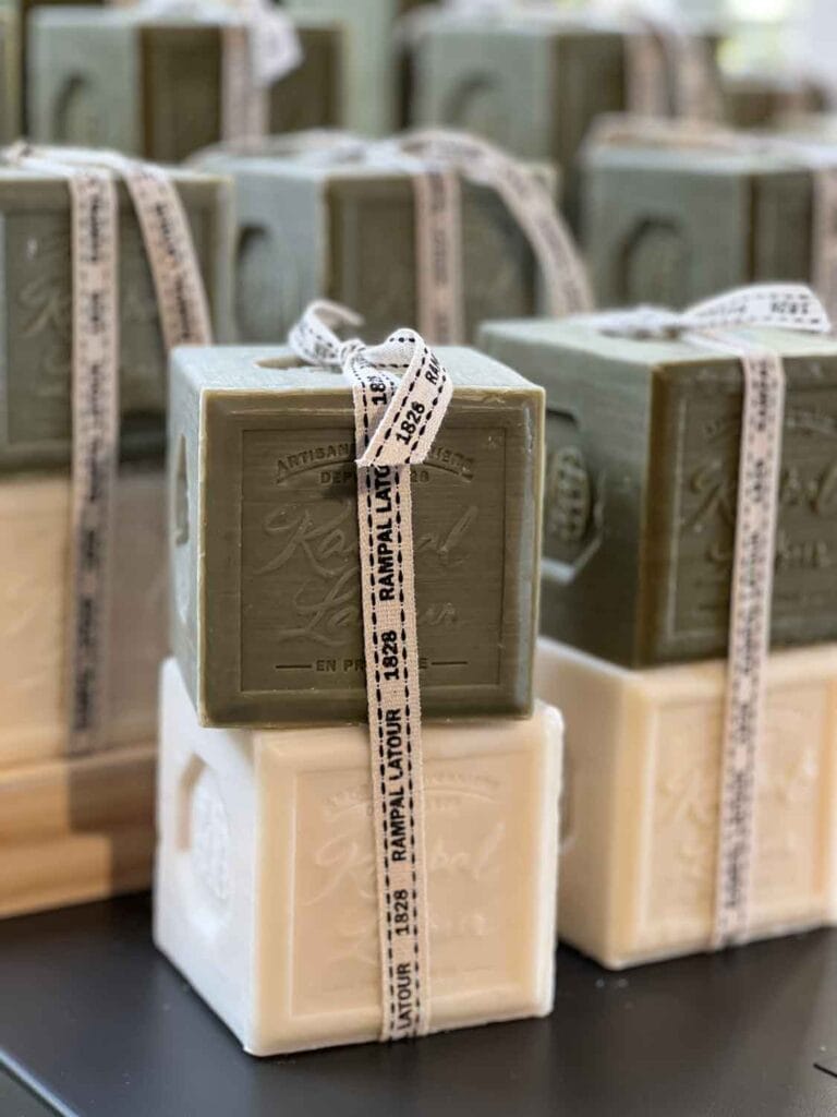Two cubes of soaps, different colors and scents, are wrapped with a small Rampal Latour ribbon.