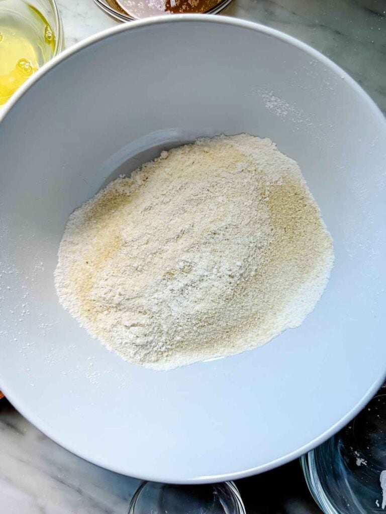 Dry ingredients have been siften into a large, white mixing bowl.