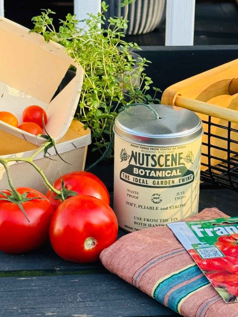 Can of twine, tomatoes on workbench.