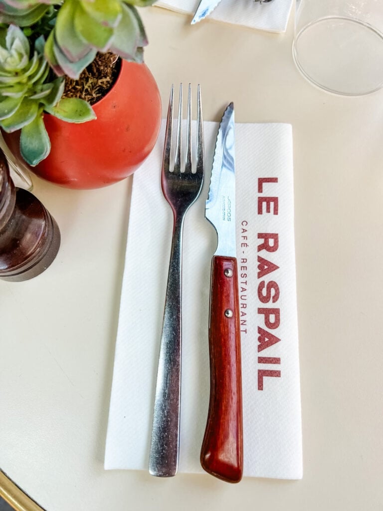 A knife and fork is on a Le Raspail napkin at this bistro in Paris.