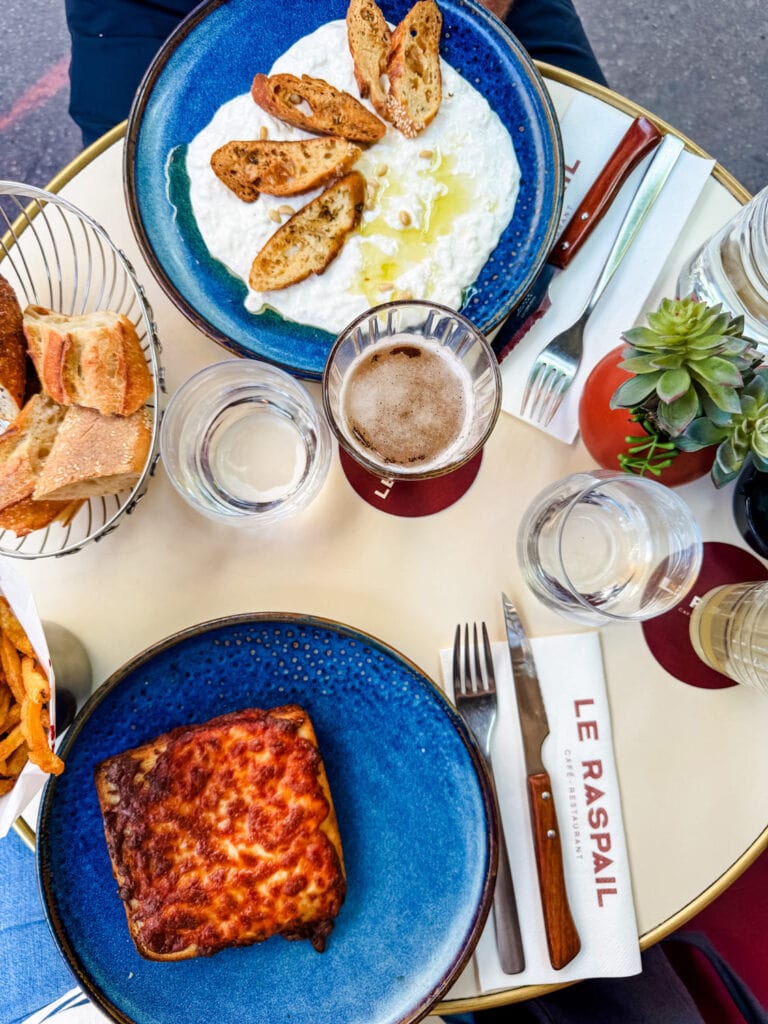Croque monsieur with French fries and a plate of baguette slices, toasted with ricotta cheese, is served at Le Raspail in Paris.