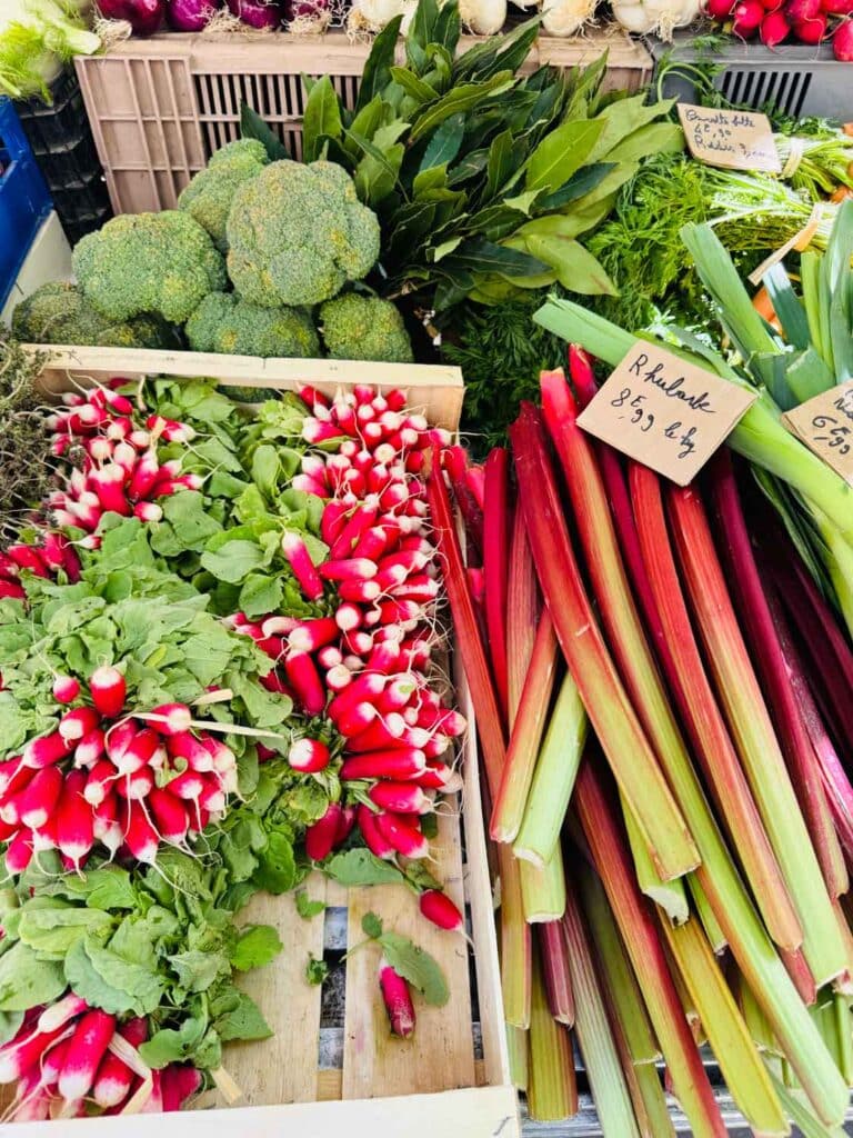 French radishes, rhubarb, and broccoli are just a few of the vegetables you can find at Marché Raspail in Paris.