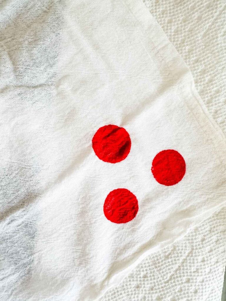 Three painted red dots on a towel.