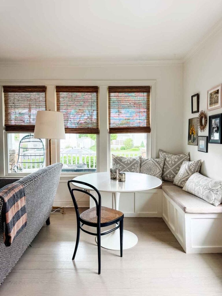White Saarinen table, Thonet chair, banquette with pillows.